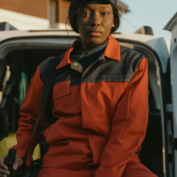 Person in orangefarbener Arbeitskleidung.